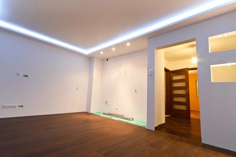 Soggiorno di un appartamento ristrutturato a Roma con parquet e controsoffitto illuminato