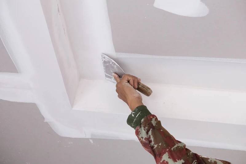 Rasatura a spatola di un controsoffitto in cartongesso prima della tinteggiatura